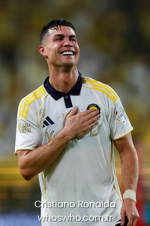 Football player Cristiano Ronaldo smiling with his hand on his chest in an Al Nassr white jersey.