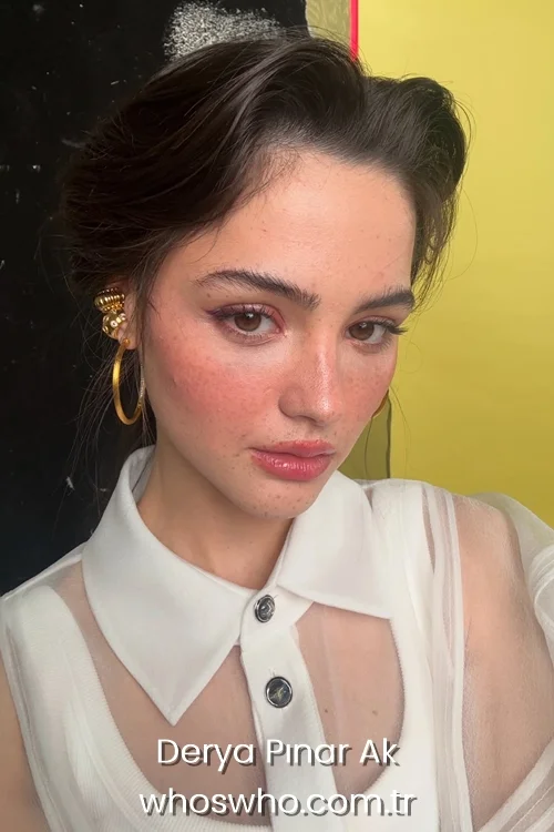 Turkish actress Derya Pınar Ak gesturing for silence with a finger over her lips outdoors at night.