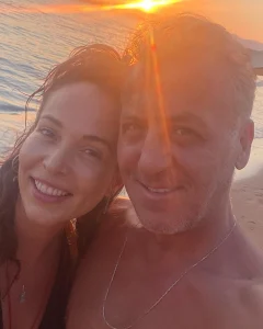 Turkish actress Esra Ronabar and her husband, actor Barış Falay, smiling together during a sunset walk on the beach.