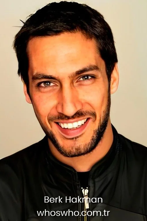 Berk Hakman smiling professional headshot portrait in a black jacket.