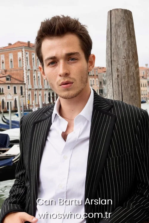 Can Bartu Arslan in a black pinstripe blazer and white shirt in Venice.