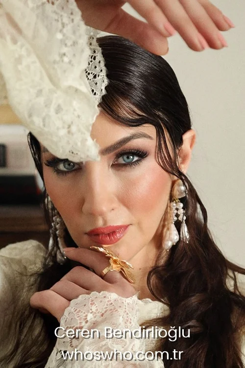 Ceren Benderlioglu close-up portrait wearing barocco pearl earrings and a gold flower ring.