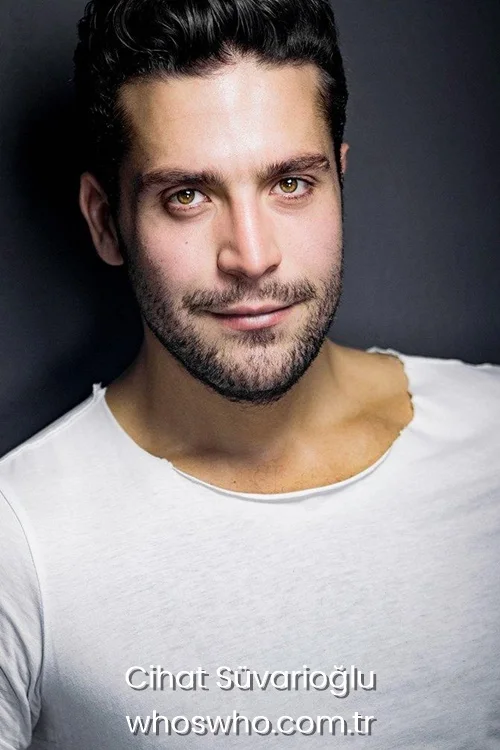 Close-up studio headshot portrait of Turkish actor Cihat Suvarioglu looking directly at the camera with a intense expression, with styled dark hair, light eyes, and short stubble, wearing a black buttoned shirt against a grey background.