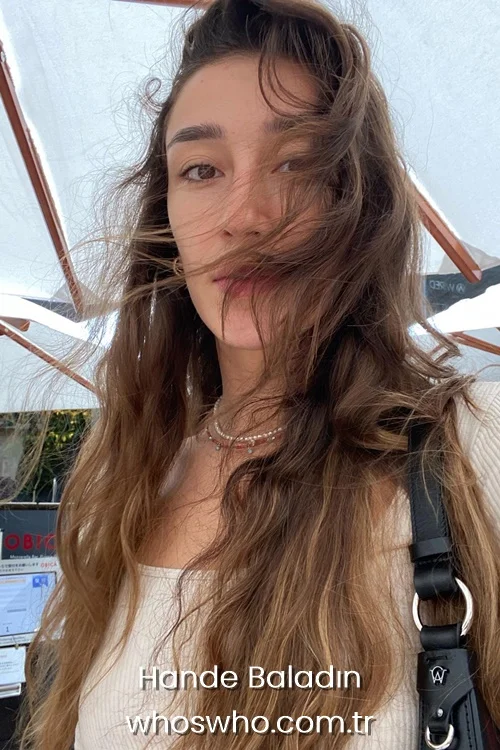 Turkish volleyball player Hande Baladın with long wavy hair looking at the camera outdoors.
