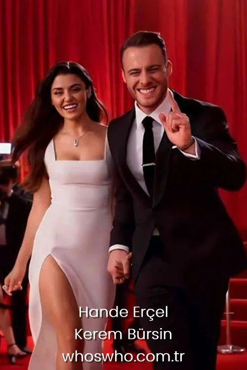 Hande Ercel in a white high-slit dress and Kerem Bursin in a black tuxedo holding hands.