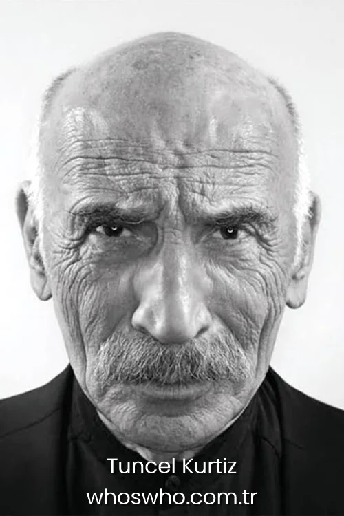 Black and white close-up portrait of Tuncel Kurtiz with an intense gaze.