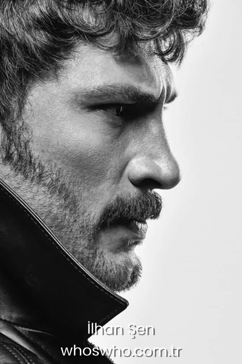 Dramatic black and white side profile portrait of Turkish actor Ilhan Sen with wavy hair, a beard, and a mustache, wearing a high-collared leather jacket with an intense gaze.