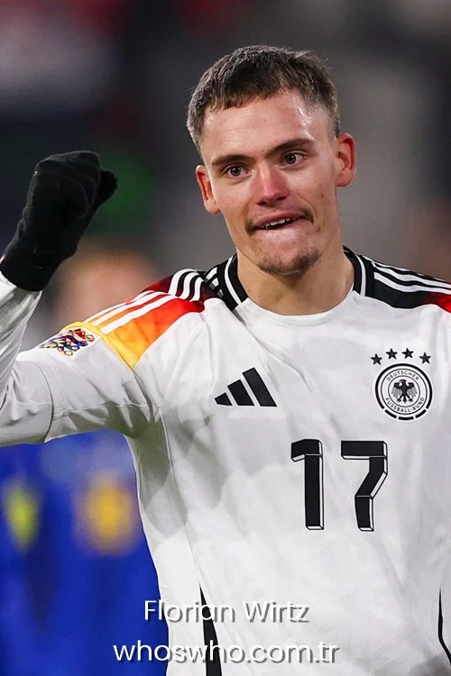 Florian Wirtz celebrating a victory in a white Germany football jersey and black gloves.