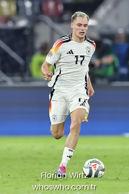Florian Wirtz running with a football on the pitch wearing Germany national team kit number 17. 