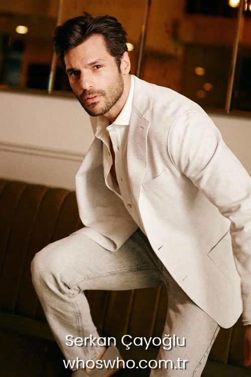 Serkan Cayoglu posing in a beige blazer jacket and matching light-colored pants. 