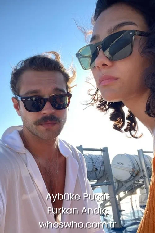 Outdoor selfie of Turkish actors Aybuke Pusat and Furkan Andic on a sunny day, both wearing stylish sunglasses. Furkan is wearing a white open-collar shirt, and Aybuke is in a mustard yellow top.
