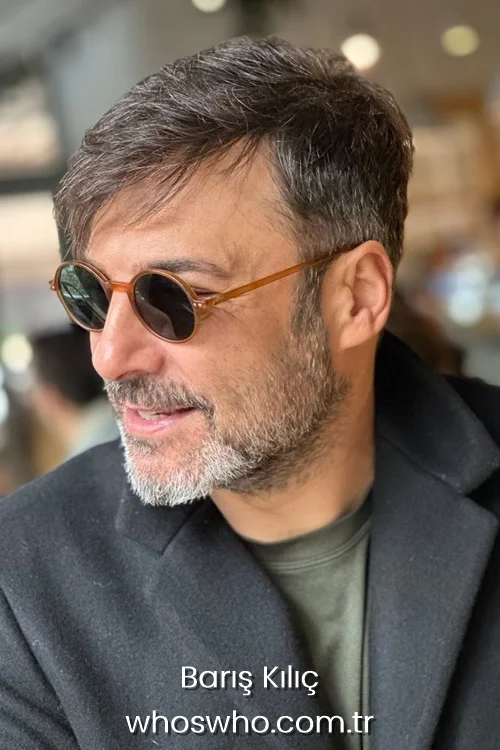 Baris Kilic in a side profile portrait wearing round tortoiseshell sunglasses and a black winter coat.