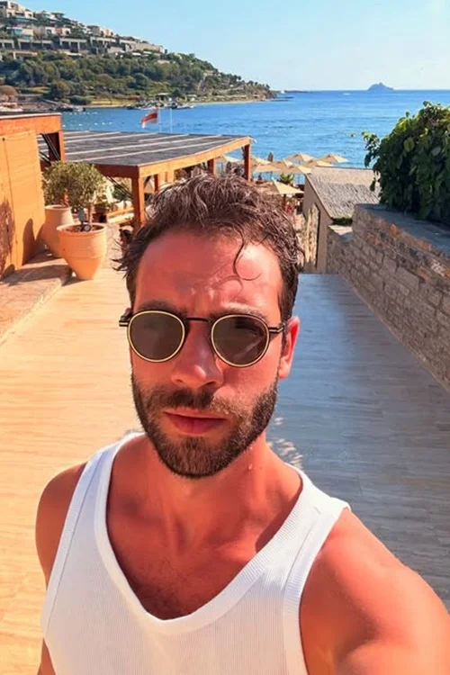Burak Berkay Akgül taking a selfie at a seaside resort during a vacation.