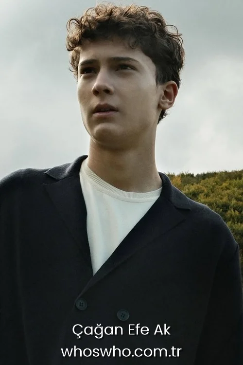 Cagan Efe Ak wearing a navy blue jacket looking away outdoors.