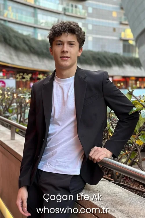 Cagan Efe Ak wearing a black blazer over a white t-shirt outdoors.
