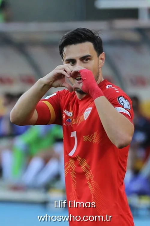 Elif Elmas making a heart shape sign with his hands on the football pitch.