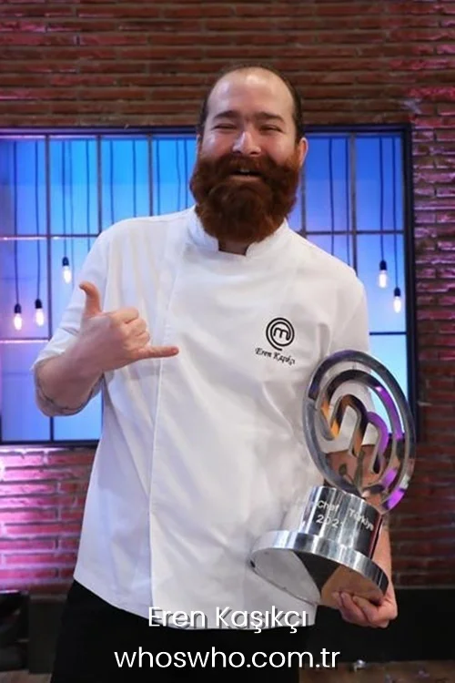 Turkish chef Eren Kasikci smiling in a white chef uniform holding the MasterChef Turkey winner trophy