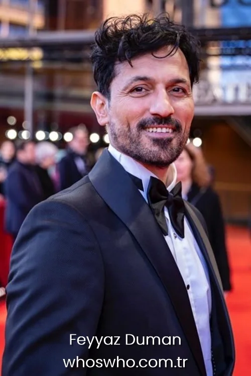 Turkish actor Feyyaz Duman smiling and wearing a classic black tuxedo with a bow tie on a red carpet event