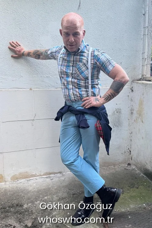 Turkish rock singer Gokhan Ozoguz wearing a blue plaid short sleeve shirt with suspenders and light blue trousers