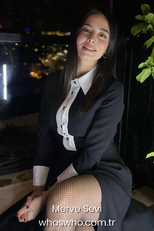 Turkish actress Merve Sevi smiling in a black and white long-sleeve dress with fishnet stockings.