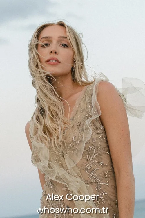 American podcaster Alex Cooper posing in an embellished beige tulle dress