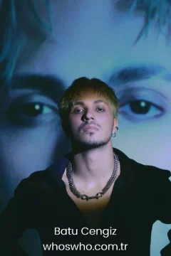 Batu Cengiz family Official close-up promotional portrait of Crush boy band member Batu Cengiz posing in an open black shirt and a heavy double-strand silver chain necklace, looking directly at the camera under dramatic lighting with a large artistic projection of eyes in the blue background.