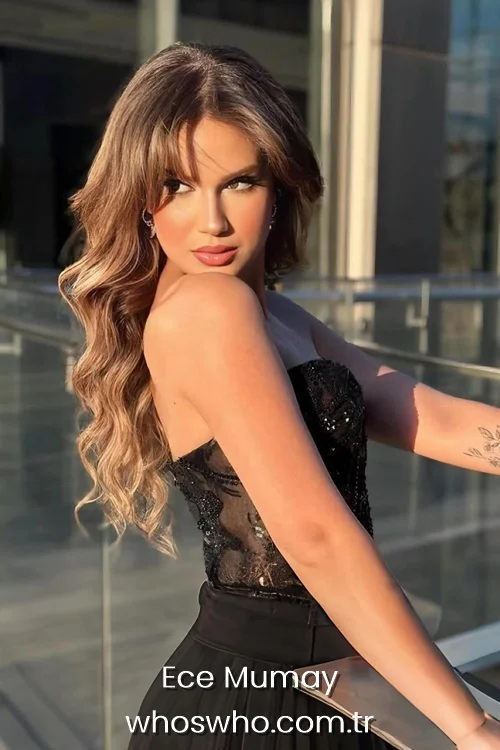 Turkish singer Ece Mumay looking over her shoulder, wearing a black strapless dress