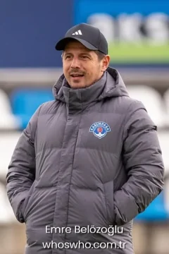 Turkish football manager Emre Belozoglu wearing a gray winter coat and cap for his official biography profile cover.