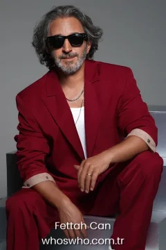 Fettah Can career Turkish singer and songwriter Fettah Can posing in a modern red suit and black sunglasses for a biography cover portrait.