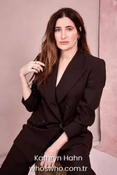 Actress Kathryn Hahn portrait wearing a dark pantsuit for her official biography profile cover.