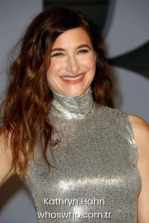 Actress Kathryn Hahn smiling in a metallic silver dress at a red carpet event.