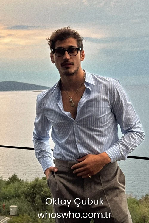 Turkish actor Oktay Çubuk posing outdoors in a striped shirt and glasses.