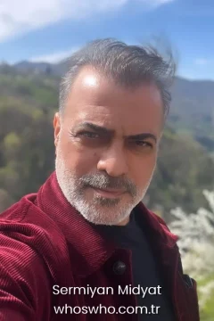 Turkish actor and director Sermiyan Midyat wearing a burgundy corduroy jacket, official biography cover photo