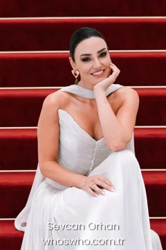 Turkish folk music singer Sevcan Orhan posing in an elegant white dress for her official biography profile cover.