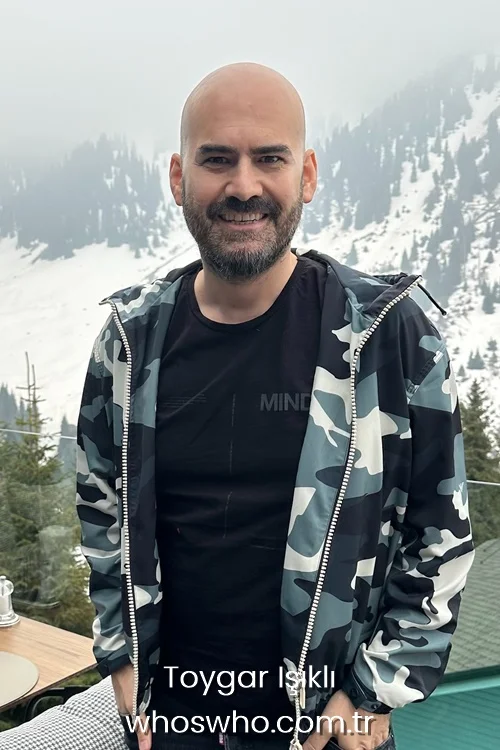 Turkish soundtrack composer Toygar Isikli wearing a camouflage windbreaker jacket in front of snowy mountains background 