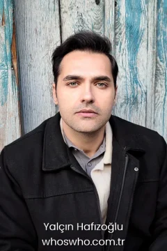 Turkish actor Yalcin Hafizoglu portrait posing against a blue wooden background for his official biography profile cover.