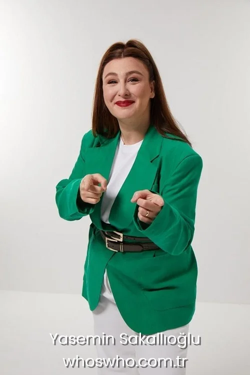 Turkish comedian Yasemin Sakallioglu smiling and pointing forward, wearing a green blazer