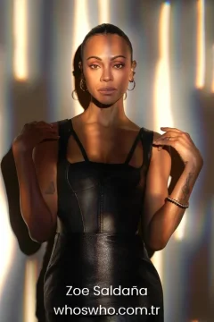 Actress Zoe Saldana portrait in a black leather dress with warm lighting for her official biography profile cover.